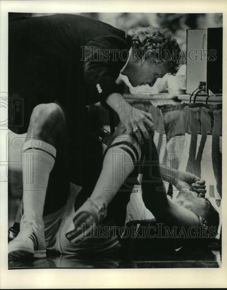 1984 Press Photo Basketball Trainer Jeff Snedeker Checks Marques Johnson&#39;s Knee- Historic Images