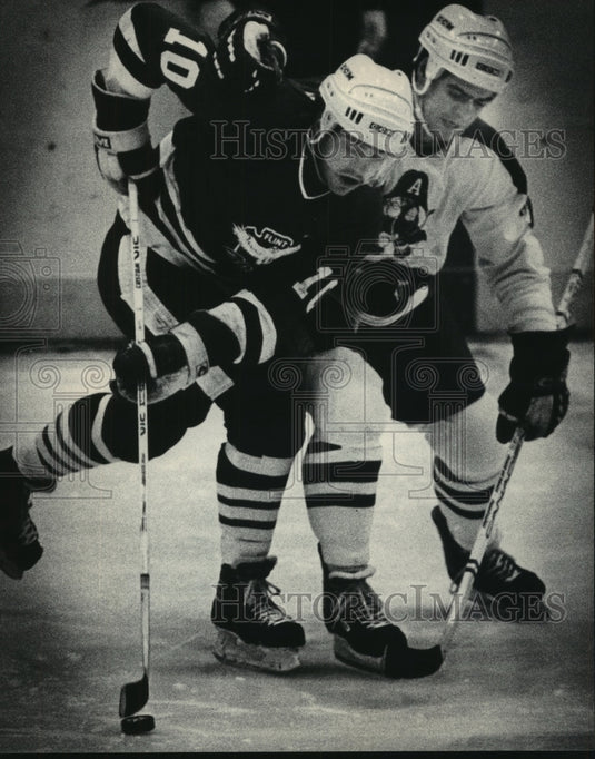 1986 Press Photo Milwaukee Admiral's Alan Graves checks Flint's Rene Breton- Historic Images
