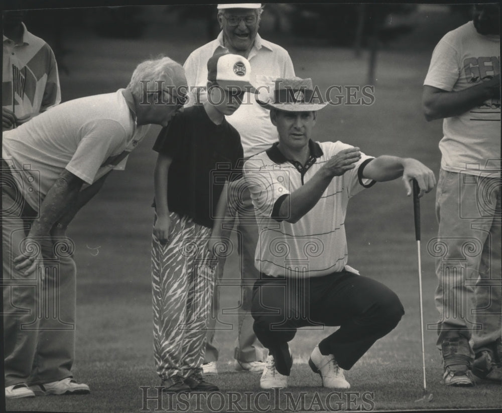 1992 Press Photo PGA Pro Andy North enlists the help of Matthew Queen on putt.- Historic Images