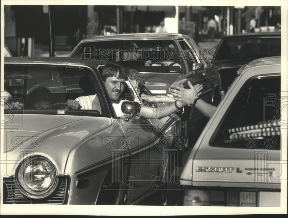 1987 Press Photo Motorists on Wisconsin Avenue exchange &#39;high five.&#39; - mjt13261- Historic Images