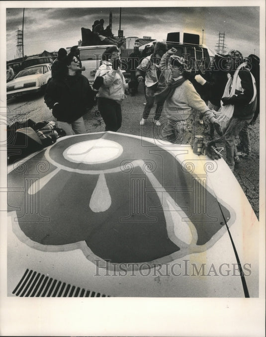 1989 Press Photo Students gather by hood of car with Brewers logo on opening day- Historic Images