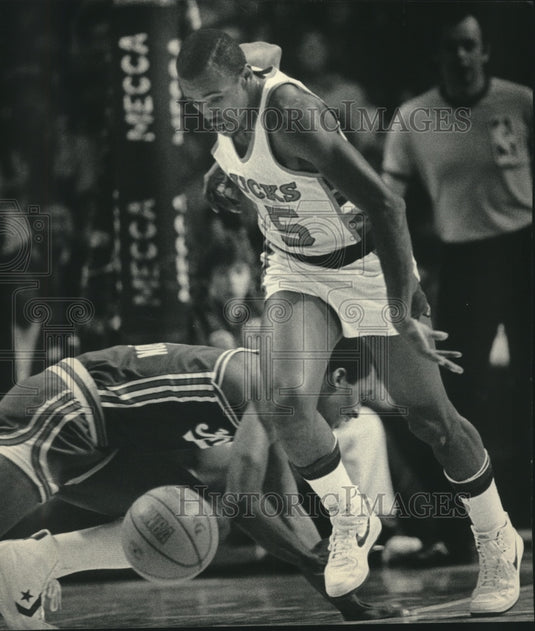 1985 Press Photo Milwaukee Bucks guard Craig Hodges chased loose basketball- Historic Images