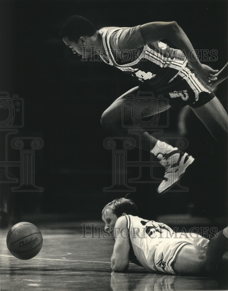 1989 Press Photo Marquette basketball player Tony Smith leaps over Furman player- Historic Images