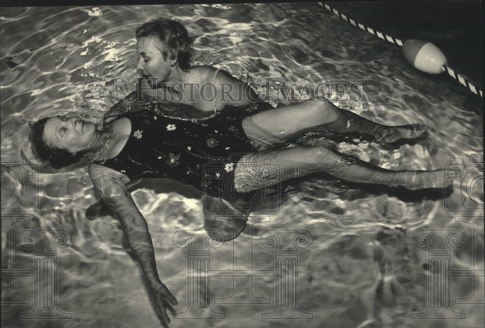 1987 Press Photo Swimming instructor Terry Sullivan teaches Irene Oster to float- Historic Images