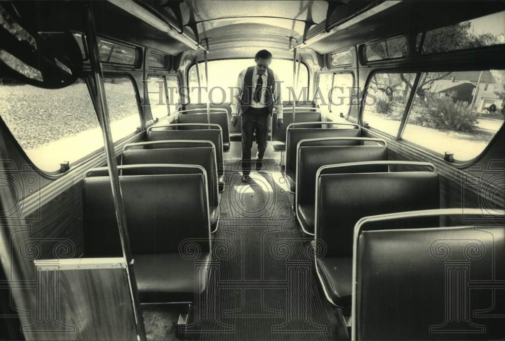 1987 Press Photo Bus driver Cecil Barton cleans the bus & checks for lost items