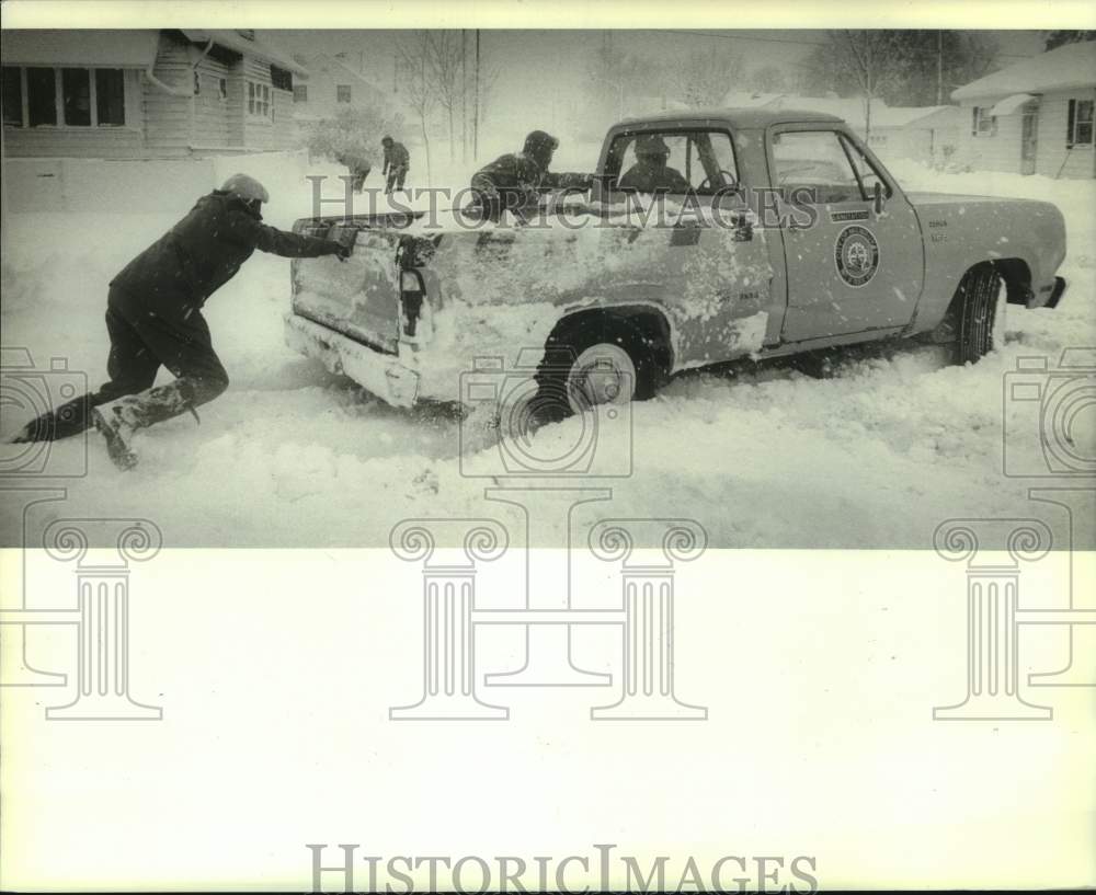 1982 Press Photo People helping Milwaukee city worker get his truck moving.- Historic Images
