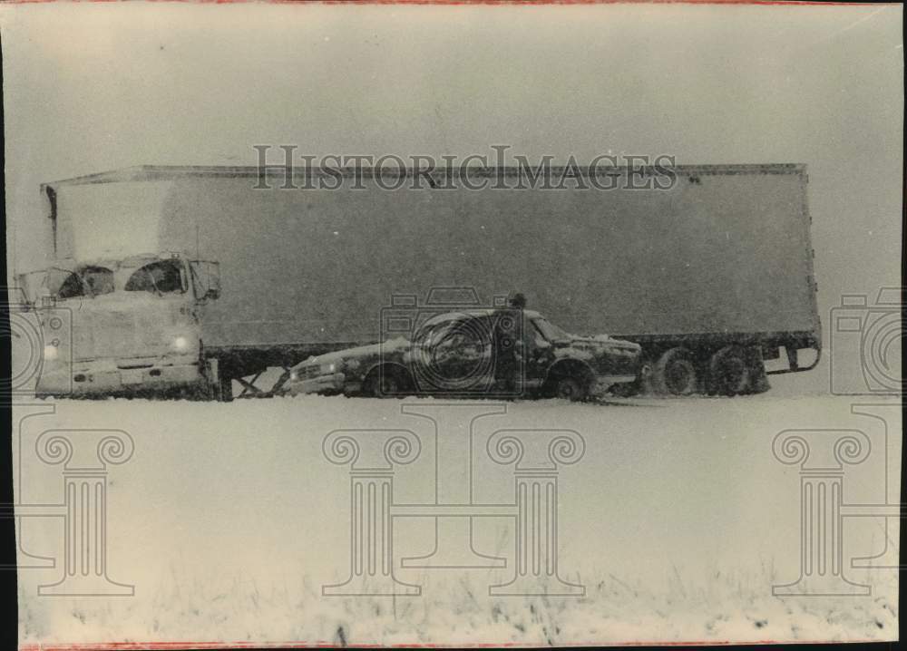 1990 Press Photo Drive checks his car after colliding with a semi-trailer.- Historic Images