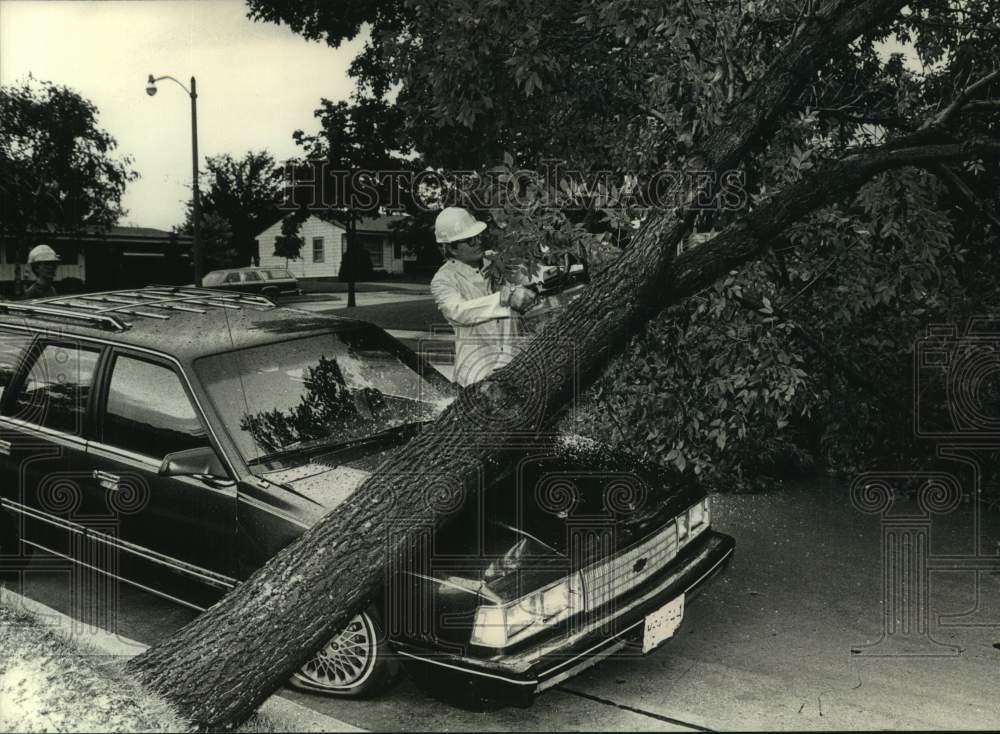 1989 Press Photo Worker removes tree from car after strong storms hit Milwaukee- Historic Images