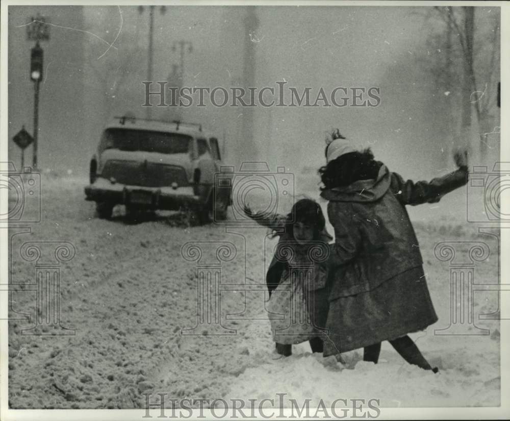 1960 Press Photo Girls slip in heavy snow brought by storm in Milwaukee