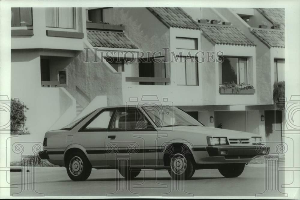 1986 Press Photo Subaru two-door hatchback parked in front of townhomes- Historic Images