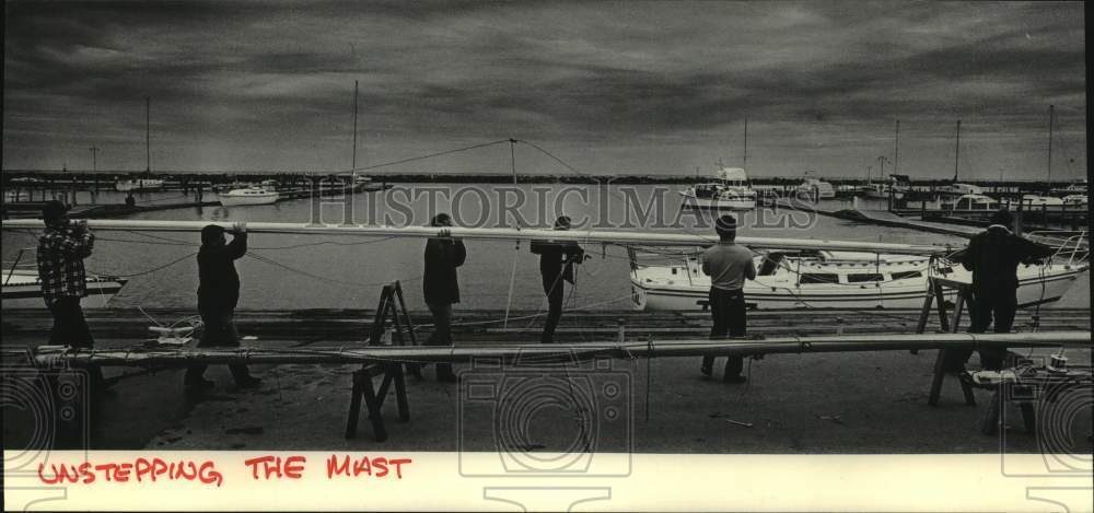 1985 Press Photo South Shore Yacht Club members help carry mast from a sailboat- Historic Images