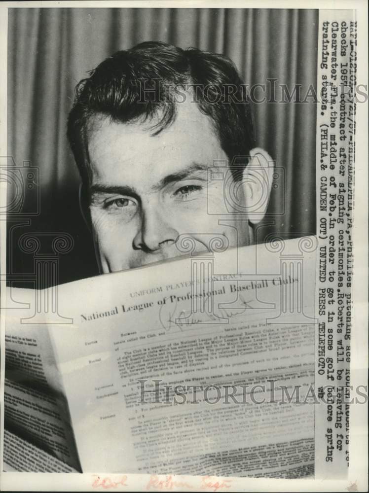 1957 Press Photo Phillies pitching ace Robin Roberts checks Baseball contract- Historic Images