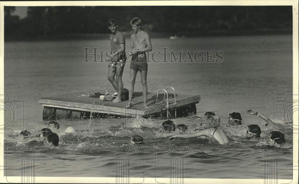 1985 Press Photo Triathlon competitors swam past a raft in Silver Lake.- Historic Images