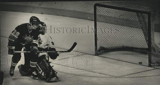 1988 Press Photo Shane MacEachern slips puck past Milwaukee Frank Caprice.- Historic Images