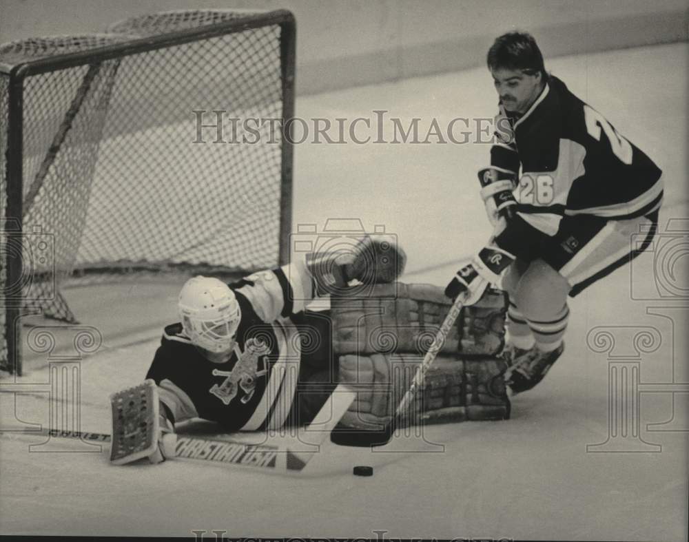 1984 Press Photo Greg Tebbutt clear puck after goalie Michel Defour stopped shot- Historic Images