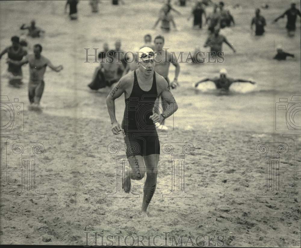 1986 Press Photo Tin Man Triathlon left water and ran across Bradford Beach.- Historic Images