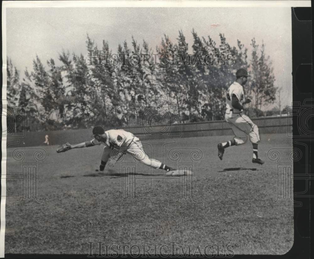 1956 Press Photo Frank Torre stretches to catch ball but runner is safe.- Historic Images