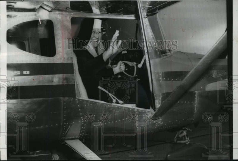Load image into Gallery viewer, 1959 Press Photo Sister Mary Aquinas waves from airplane that she will fly.
