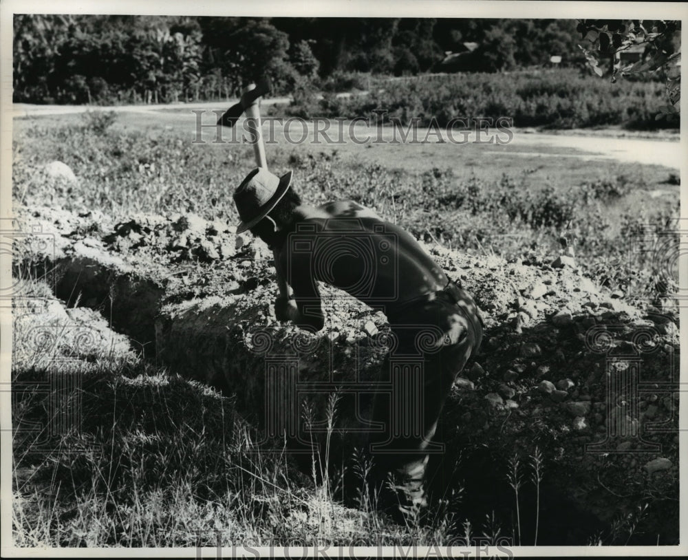 1964 Press Photo Soldier digs foxhole, Village of Borikane, Laos Civil War