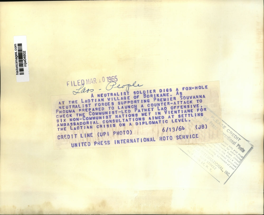 1964 Press Photo Soldier digs foxhole, Village of Borikane, Laos Civil War