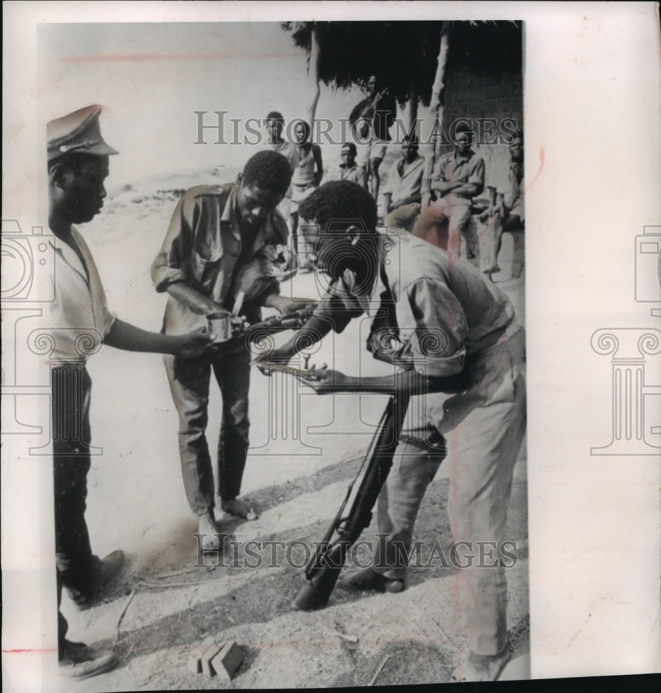 1964 Press Photo Soldiers use fat from corned beef to grease rifles in the Congo- Historic Images