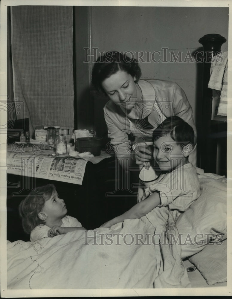 Load image into Gallery viewer, 1937 Press Photo Nurse Gladys Fitzgerald cares for sick children in their home.
