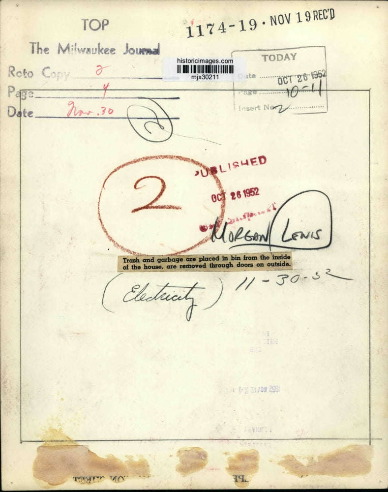 1952 Press Photo Woman places trash and garbage into a bin from inside house