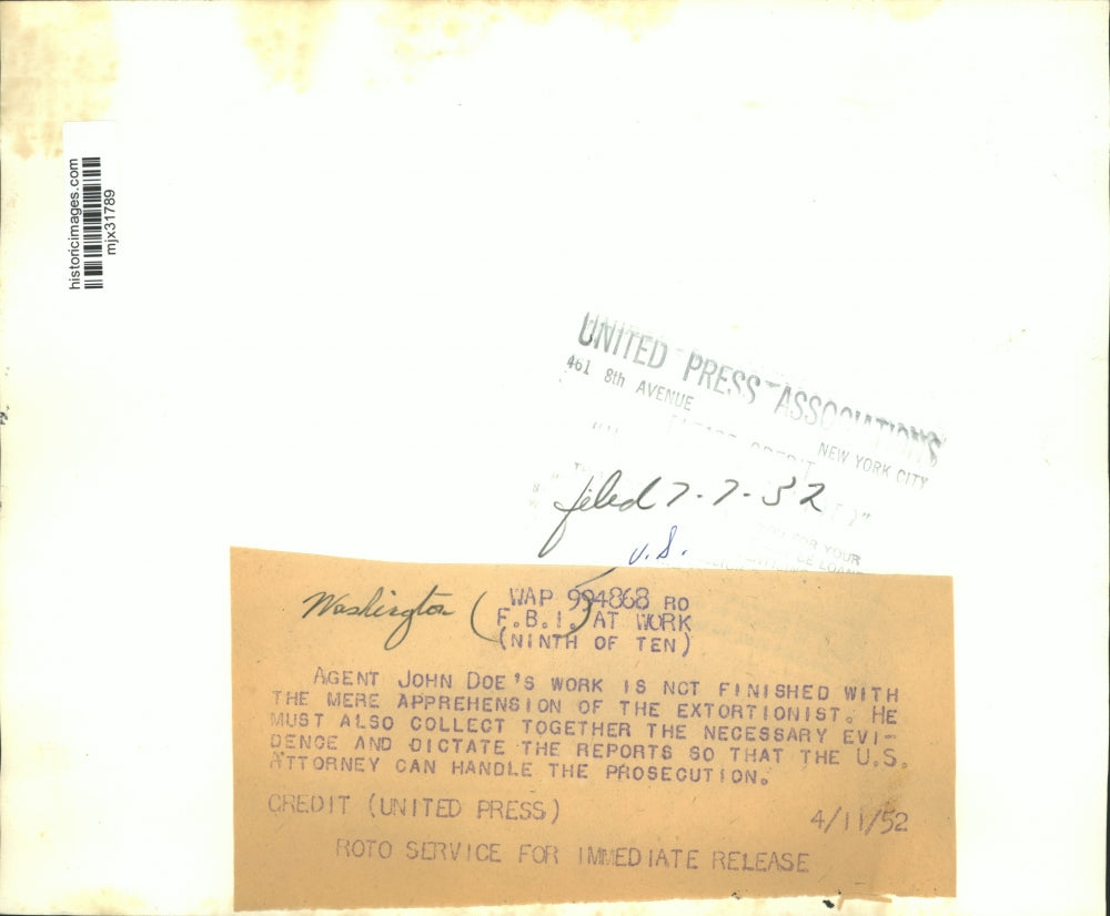 1952 Press Photo An FBI agent goes over paperwork at his desk - mjx31789