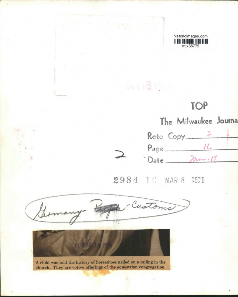 1955 Press Photo Boy and man looking at horseshoes in a church in Germany