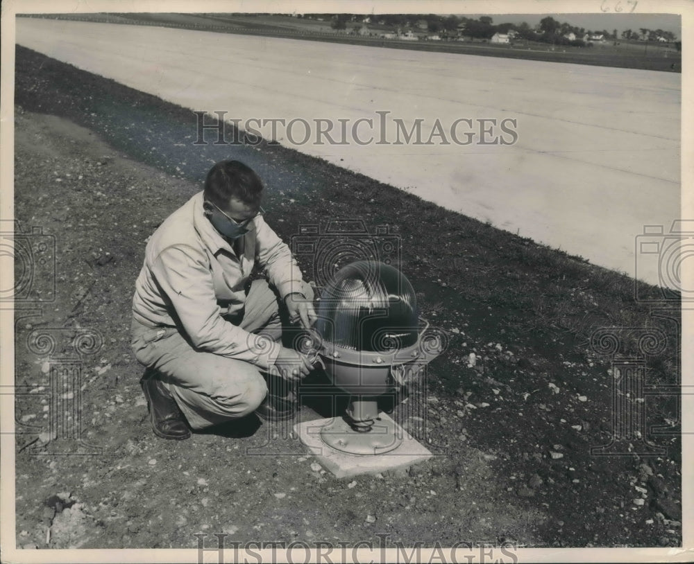1949 Press Photo Joseph Sanek Inspects Runway Light, Gen. Mitchell Field, Wis.- Historic Images