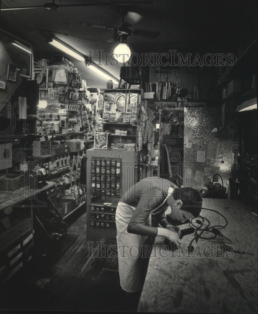 1985 Press Photo Ellen Miller Repairing Machine in Her Hardware Store- Historic Images