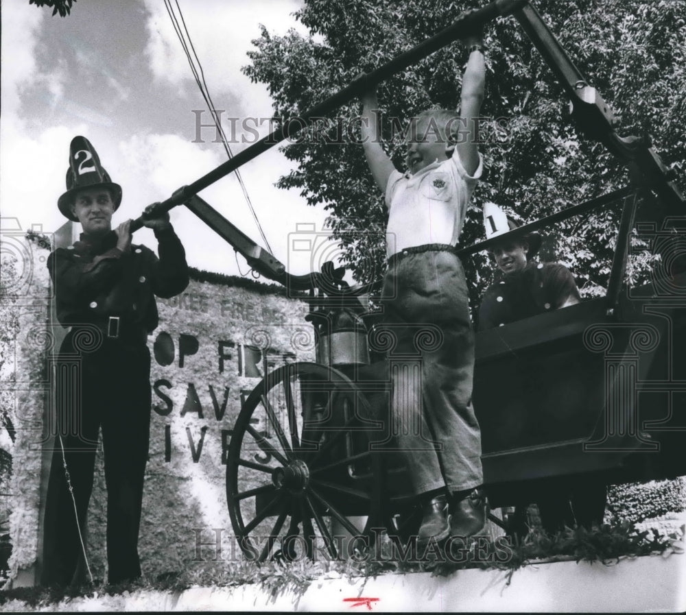 1958 Press Photo Donald Neldner hoisted himself on bar of a 1880 hand pumper.
