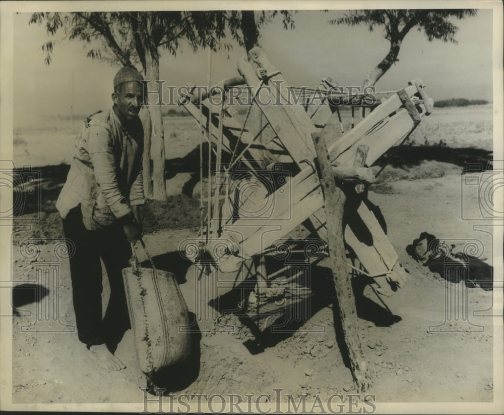 1952 Press Photo In primitive hoist bring sack filled with sand to surface.- Historic Images