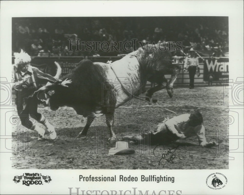 1989 Press Photo Rodeo clown steers bull away from cowboy; Rodeo in Milwaukee- Historic Images