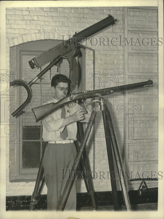 1940 Press Photo William Foy inspects a Harper's Ferry sniper's gun on tripod- Historic Images