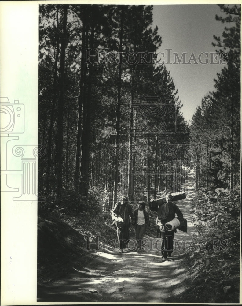 Load image into Gallery viewer, 1983 Press Photo Rainbow Family World Peace Gathering Campers walk a trail
