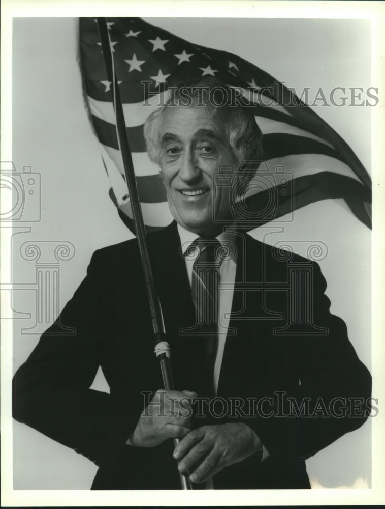 1989 Press Photo Pat Paulsen, comedian, holding American Flag. - mjx60560- Historic Images