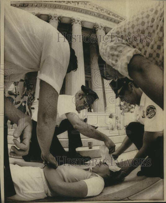 1974 Press Photo Police and volunteers attend to fainted woman at Supreme Court- Historic Images