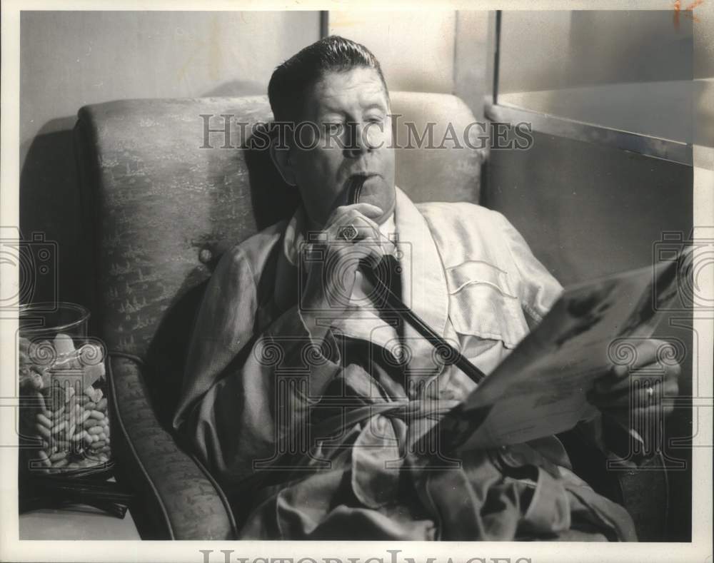 1964 Press Photo Actor Rudy Vallee in relaxing eating licorice - mjx77618- Historic Images