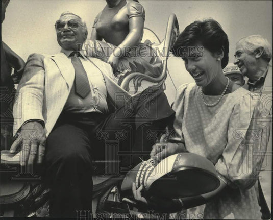 1985 Press Photo Ernest Borgnine tries on new clown shoes aided by Joy Altenbach- Historic Images