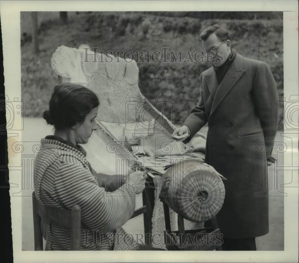 1950 Press Photo Man Looks Over Lace Worker's Handicraft At Stand In Genoa Italy