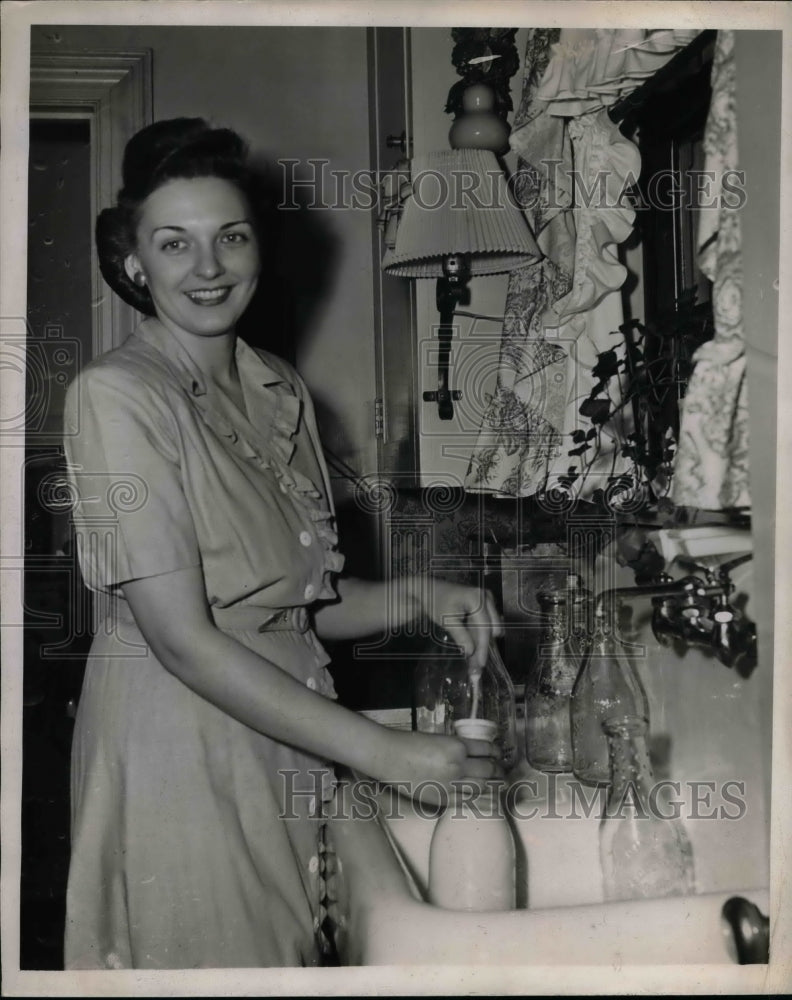 Load image into Gallery viewer, 1945 Press Photo Mrs. George C. Miller of Toledo with Milk Bottles - nea30792
