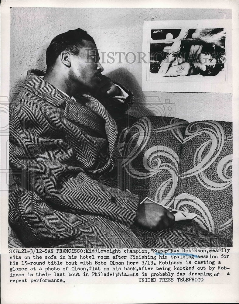 1952 Press Photo Sugar Ray Robinson Gazes At Picture Of Knocked Out Bobo Olson