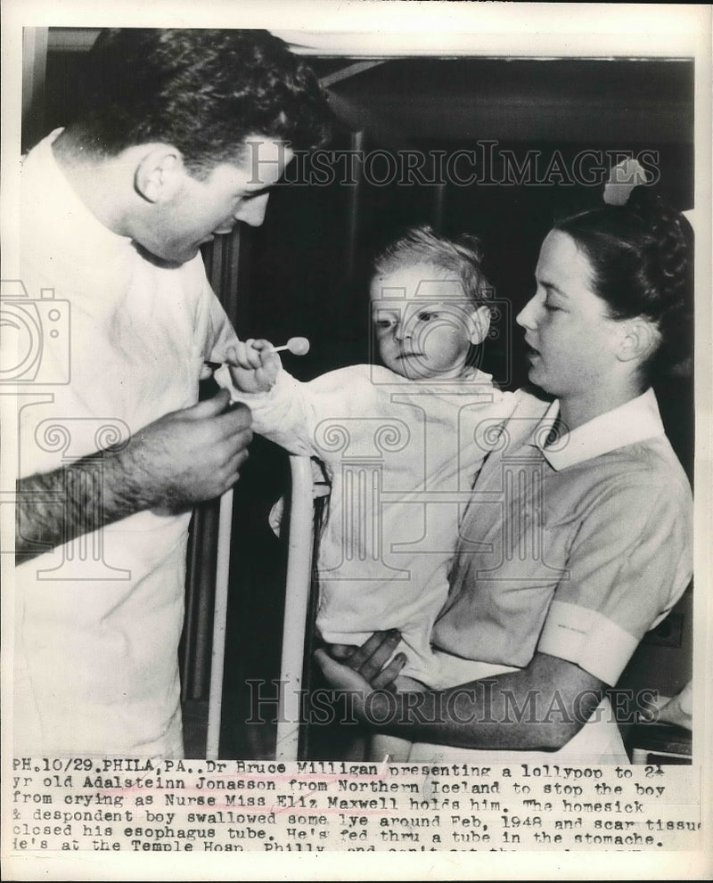 Load image into Gallery viewer, 1929 Press Photo Dr. Bruce Milligan Gives Adalsteinn Jonasson Lollypop

