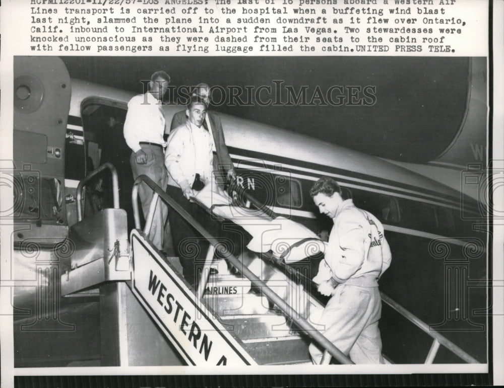 1957 Press Photo Person abroad Western Air Liner is carried off to the Hospital
