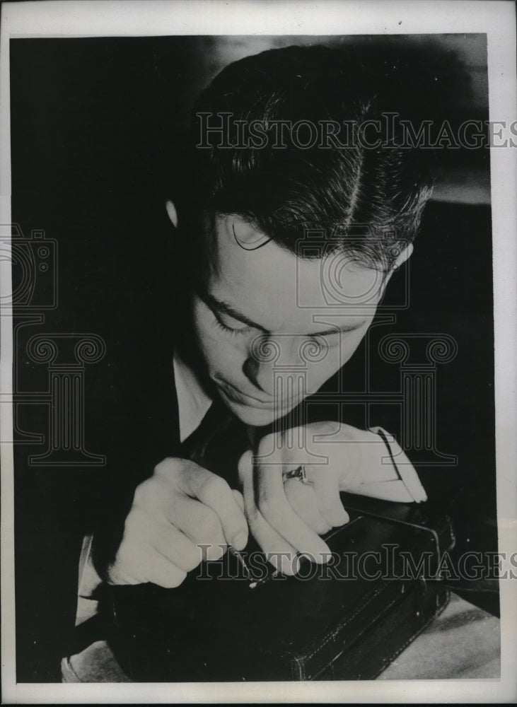 1934 Press Photo Larry E.Anderson demonstrates writing on grain of rice- Historic Images