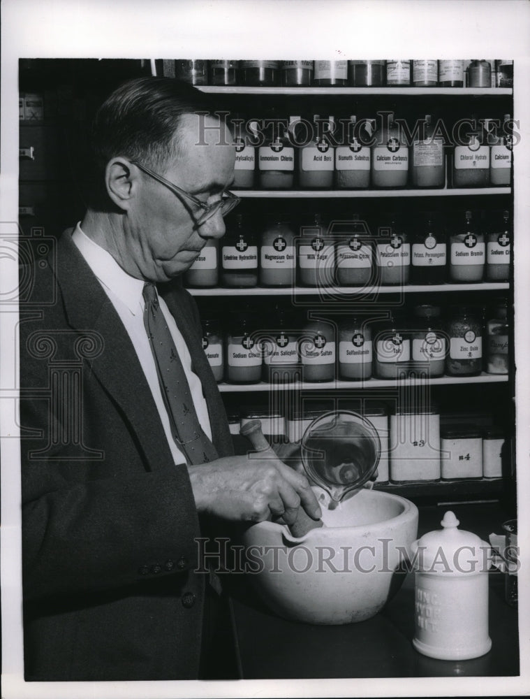 1957 Press Photo pharmacist making drugs with a mortal and pestle