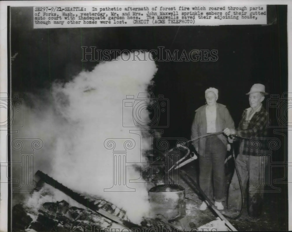 1951 Press Photo Mr. & Mrs. John Maxwell sprinkle embers after forest fire