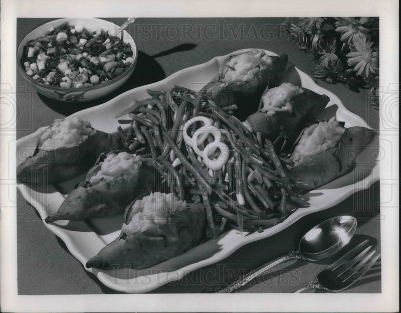 Load image into Gallery viewer, 1955 Press Photo A platter of baked sweet potatoes with green bean garnishes
