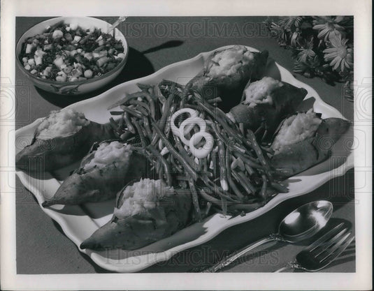 1955 Press Photo A platter of baked sweet potatoes with green bean garnishes
